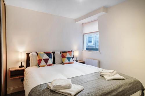 a bedroom with a bed with two towels on it at Apt 3, Soho Apartments 2nd & 3rd floors by Indigo Flats in London