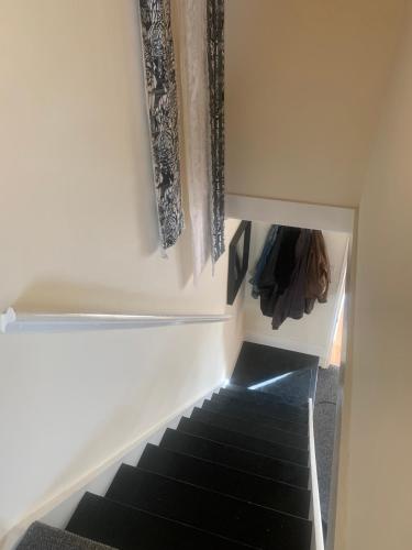 a hallway with a staircase with black carpeting and curtains at Apartment, Stylish 2 bed Riverside House, 2 Kingsize beds, Free Parking in Southampton