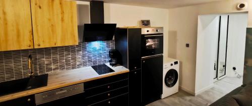 una cucina con fornelli e microonde di Ste Cosy a Istres