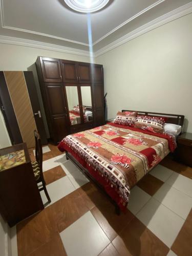 a bedroom with a bed with a red blanket on it at Paradise residence in Dumyāţ al Jadīdah