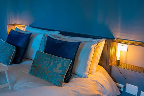 a bedroom with a bed with pillows and a lit lamp at LaMalatestina Suite - Apartment in front of the Castle in Rimini