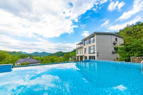 a large swimming pool in front of a building at Anji Bamboo Homestay in Tangkou