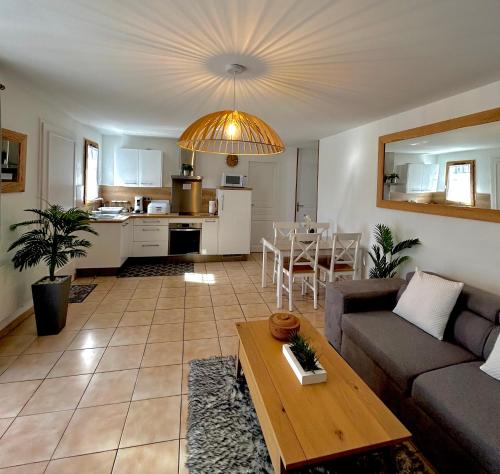 a living room with a couch and a table at Maison tout confort au calme idéal famille 4ESTGNT7 in Le Barcarès