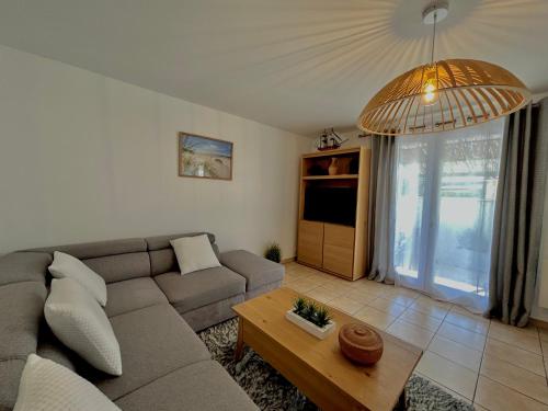 a living room with a couch and a table at Maison tout confort au calme idéal famille 4ESTGNT7 in Le Barcarès