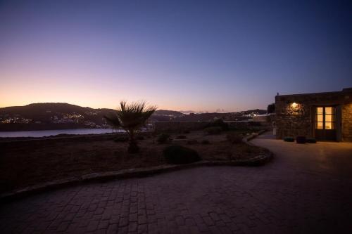 a pathway leading to a house with a sunset in the background at Private apartment sea view yard in Mýkonos City