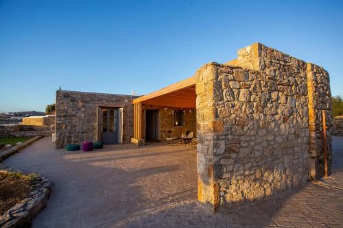 a stone building with a stone wall next to it at Private apartment sea view yard in Mýkonos City