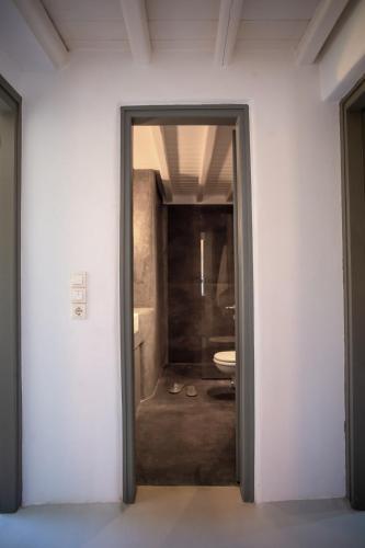 a door leading to a bathroom with a toilet at Private apartment sea view yard in Mýkonos City