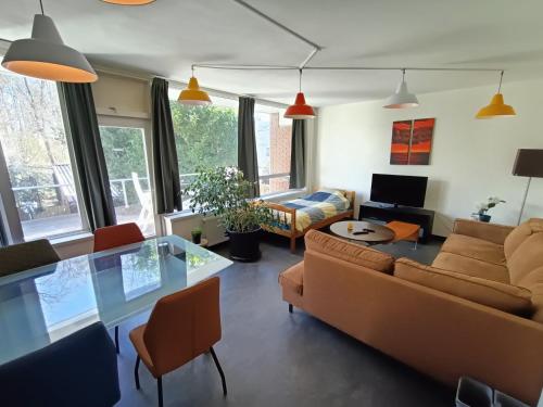 a living room with a couch and a table at Stylish 3BR Villa - Rooftop Lounge - Big Kitchen in Heerlen