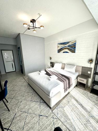 a bedroom with a large white bed in a room at Beshchinor Hotel in Yakkasaray