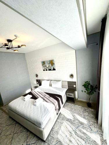 a bedroom with a bed and a white wall at Beshchinor Hotel in Yakkasaray