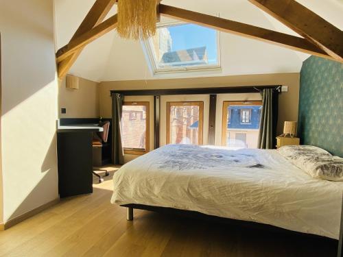 Un dormitorio con una cama grande y una ventana. en La TOUR, en Rodez