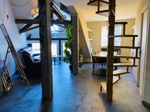 un salon avec un escalier en colimaçon et une table dans l'établissement La TOUR, à Rodez