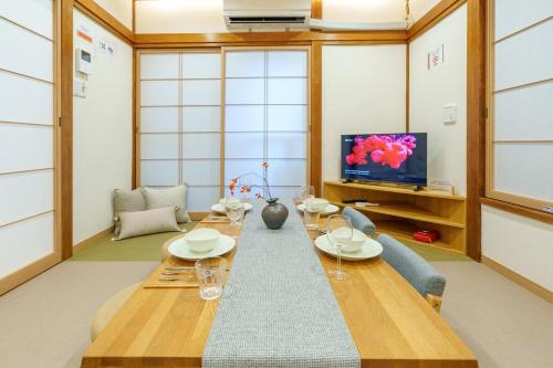 a living room with a long table and a tv at MINE HOME東中野 116t in Tokyo