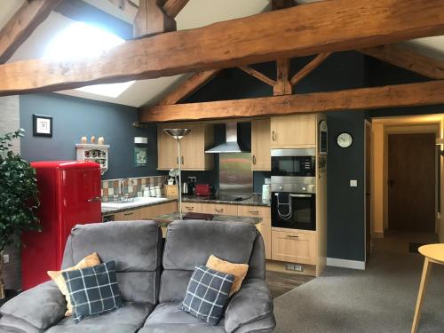 a living room with a couch and a kitchen at The Granary with hot tub - 2 miles from Skipton in Carleton
