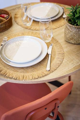 une table en bois avec des assiettes et des verres à vin dessus dans l'établissement Stud Terra 2pers wifi city center, à Cambrai