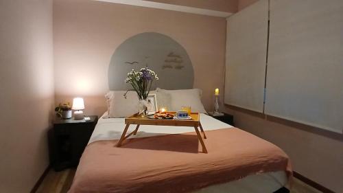 a bedroom with a bed with a table with flowers on it at Viraro Apart - Apto céntrico con estacionamiento in Salto