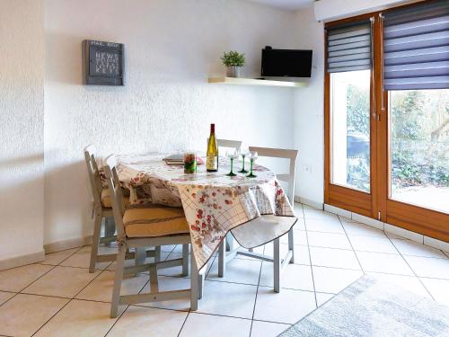 - une salle à manger avec une table et une bouteille de vin dans l'établissement Le Cocon appart avec parking privé & terrasse, à Sainte-Croix-en-Plaine