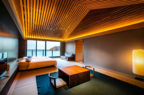 a bedroom with a bed and a table and a couch at シーサイド佐竹 in Kyotango
