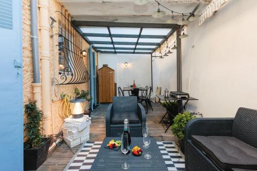 - une terrasse avec des chaises et une table avec une bouteille de vin dans l'établissement Perrissol YourHostHelper, à Cannes