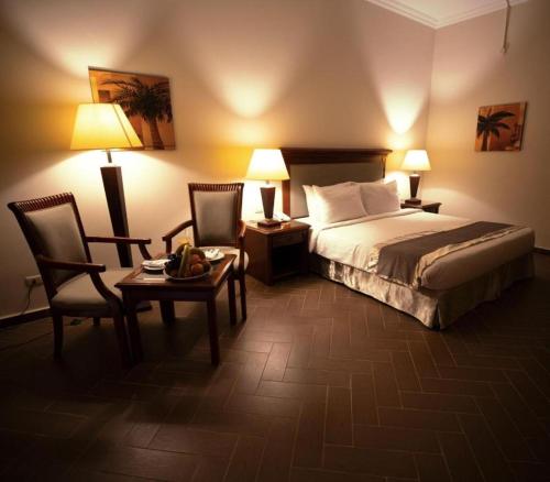 a hotel room with a bed and a table and chairs at La Rosa Empire Hotel-Ain Sokhna in As Suways