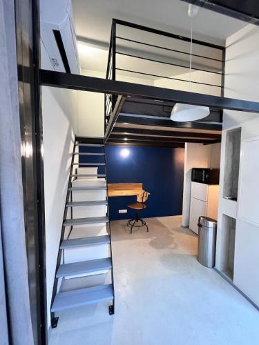 Un escalier mène à une chambre avec une table. dans l'établissement Folie sur Cour à Palavas-les-Flots 3 etoiles, à Palavas-les-Flots