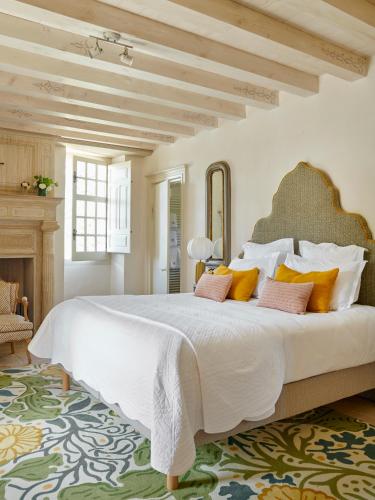 une chambre avec un grand lit blanc avec des oreillers orange dans l'établissement Fronsac, à Vieux-Mareuil