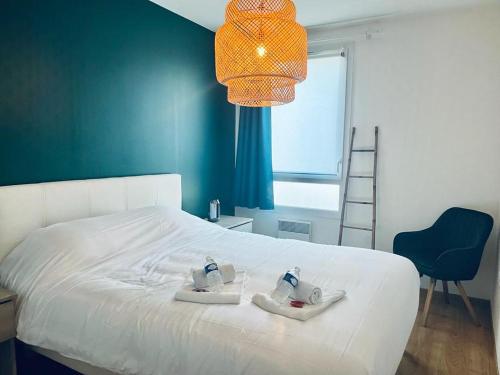 une chambre avec un lit blanc avec un mur bleu dans l'établissement charbonnier 6 personnes avec terrasse et parking, à Reims