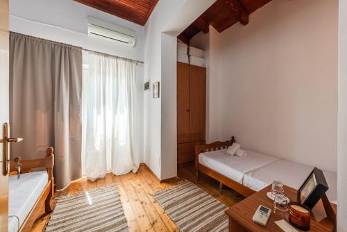 a bedroom with two beds and a table and a window at 'Easy Steps' Guesthouse - Room 1 - Pro Bono in Shkodër
