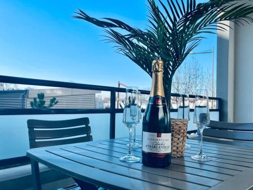 une bouteille de vin posée sur une table avec des verres dans l'établissement charbonnier 6 personnes avec terrasse et parking, à Reims