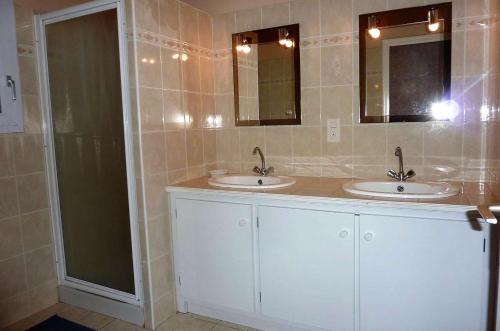 une salle de bain avec deux lavabos et deux miroirs dans l'établissement Maison 5 pièces 6 couchages Saint Georges d'Oléron SGO000-684, à Saint-Georges-dʼOléron