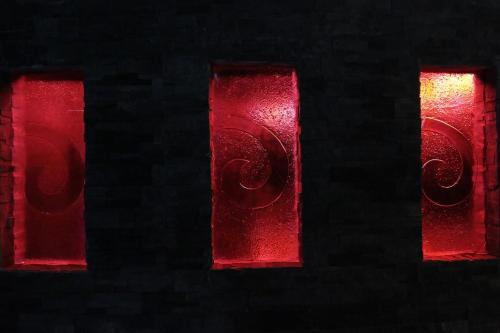a red light in a brick wall with two windows at Maitai Lapita Village Huahine in Fare