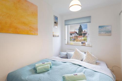 a bedroom with a bed with two pillows and a window at Sonnige, ruhige Gartenwohnung mit Terrasse u. Garten in Oberhaching