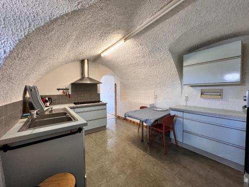 Il comprend une cuisine équipée d'un évier, d'une cuisinière et d'une table. dans l'établissement Le Gîte du Port, à Saint-Pierre-de-Boeuf