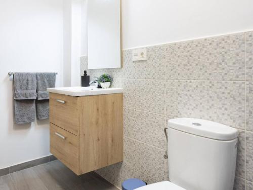 a bathroom with a white toilet and a sink at Los Eucaliptos in Fasnia