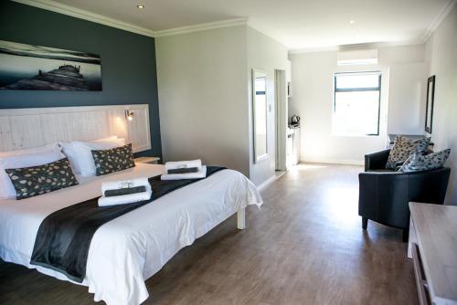 a bedroom with a large bed and a chair at Bona Vista Self-Catering Accommodation in Klapmuts