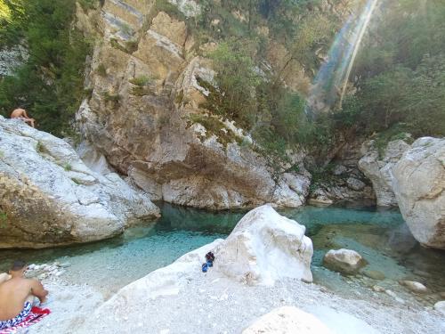 a group of people in a pool of water with a waterfall at Appartamento Palazzo Gattolini Venzone in Venzone