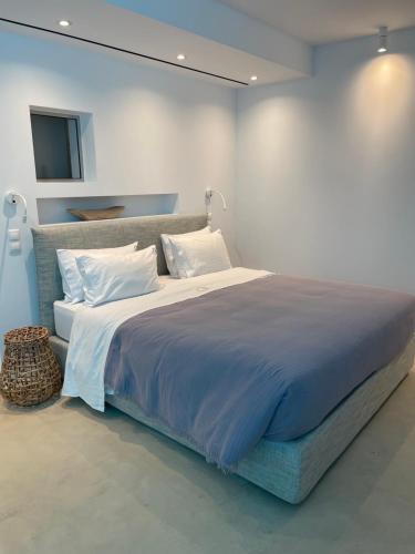 a bedroom with a large bed with blue sheets and pillows at Gialova SUNSET VILLA with Seaview & Private Pool in Gialova