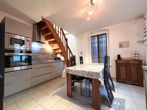 une cuisine avec une table et un escalier. dans l'établissement Chez Philippe- Clim Wi-Fi Parking - CLG Savoie, à Saint-Jean-de-la-Porte