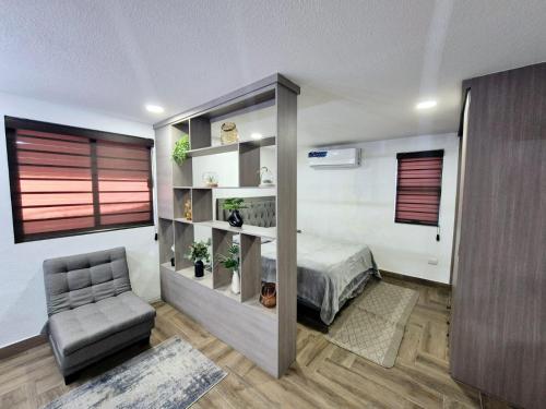 a bedroom with a bed and a chair in a room at Elegante Loft Pitagoras 1 in San Lorenzo