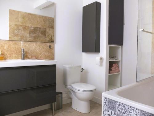 La salle de bains est pourvue de toilettes, d'un lavabo et d'une baignoire. dans l'établissement Appartement Centre Historique, à LʼIsle-sur-la-Sorgue