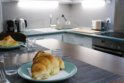 une assiette avec un croissant sur une table dans la cuisine dans l'établissement Appartement Centre Historique, à LʼIsle-sur-la-Sorgue
