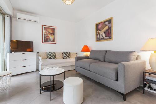 un salon avec un canapé et une télévision dans l'établissement Le Vendôme - Hypercentre - AC - Terrace - Palais of Festivals - Croisette, à Cannes