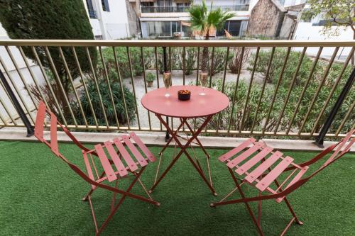 d'une table rouge et de deux chaises sur un balcon. dans l'établissement Le Vendôme - Hypercentre - AC - Terrace - Palais of Festivals - Croisette, à Cannes