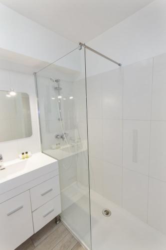 une salle de bain blanche avec une douche et un lavabo dans l'établissement Le Vendôme - Hypercentre - AC - Terrace - Palais of Festivals - Croisette, à Cannes