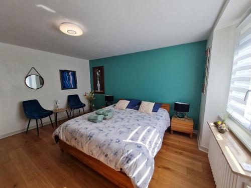 une chambre avec un grand lit avec un mur bleu dans l'établissement Appartement avec jardin, à Saint-Malo