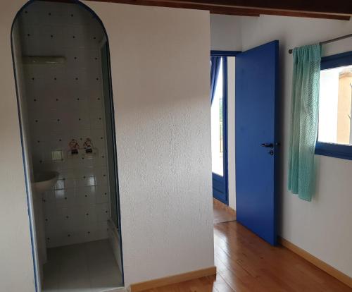 La salle de bains est pourvue d'un miroir et d'une porte bleue. dans l'établissement La villa Espérance, à Grasse