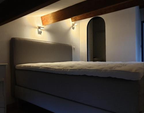 - un lit dans une chambre à côté d'un miroir dans l'établissement La villa Espérance, à Grasse