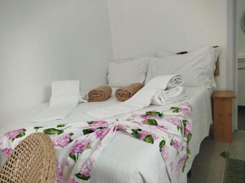 a bed with white sheets and pillows on it at Aldeia Dos Caldeirões in São Mateus
