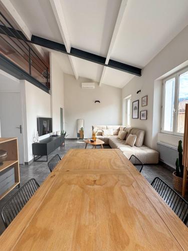 un grand salon avec une grande table en bois dans l'établissement L'Escale - Clim- Parking - Wi-Fi, à Cassis