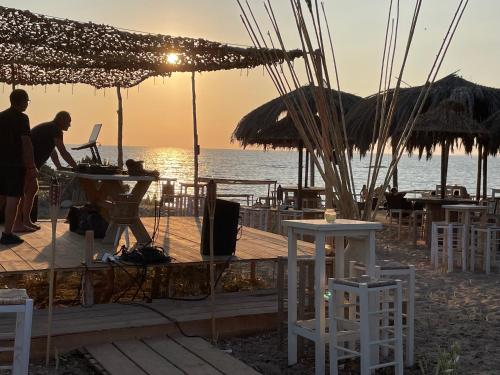 a couple of people standing on a beach with a laptop at Gialova SUNSET VILLA with Seaview & Private Pool in Gialova